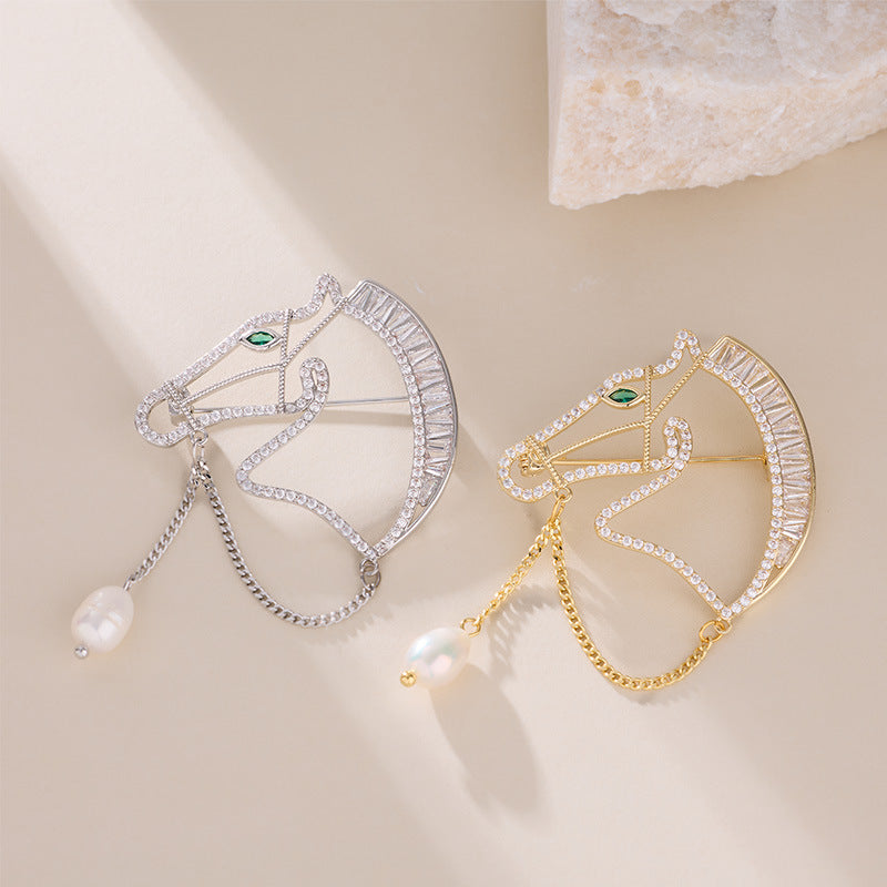 Gold and silver horse brooches side by side