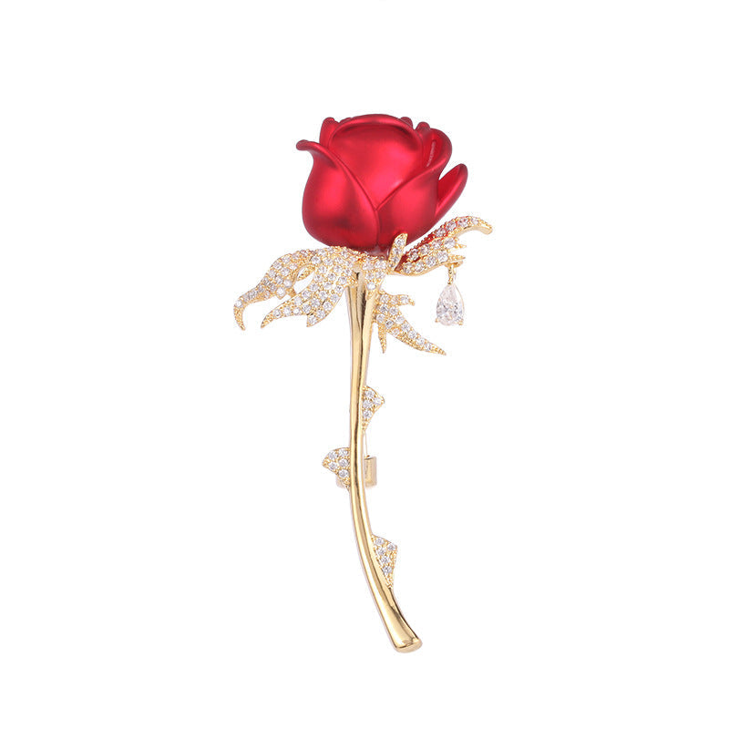 Red rose brooch with gold zircon stem on white background