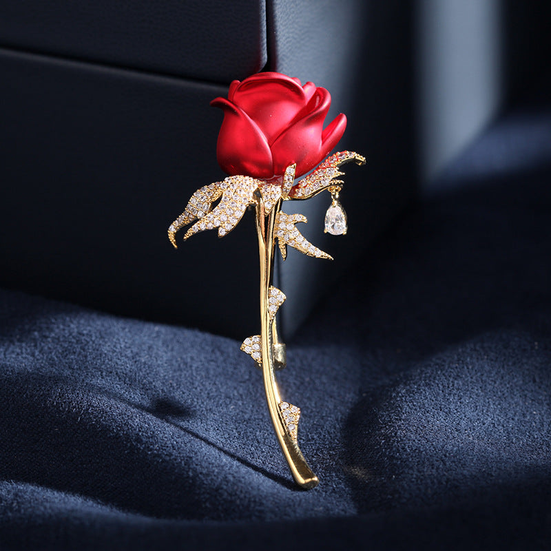 Red enamel rose brooch with zircon leaves on navy velvet