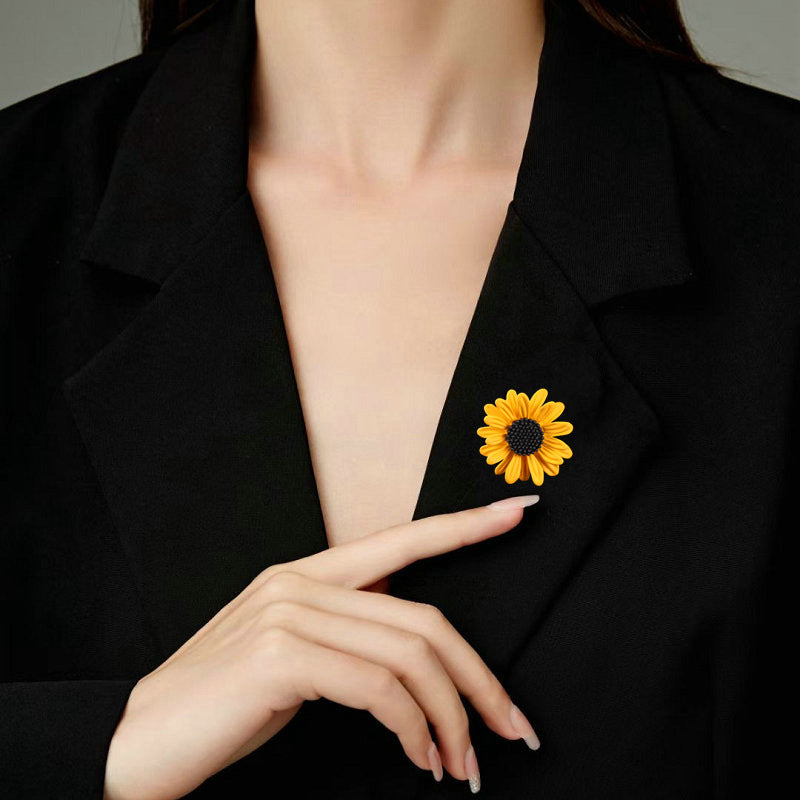 Sunflower brooch worn on a black blazer, detail