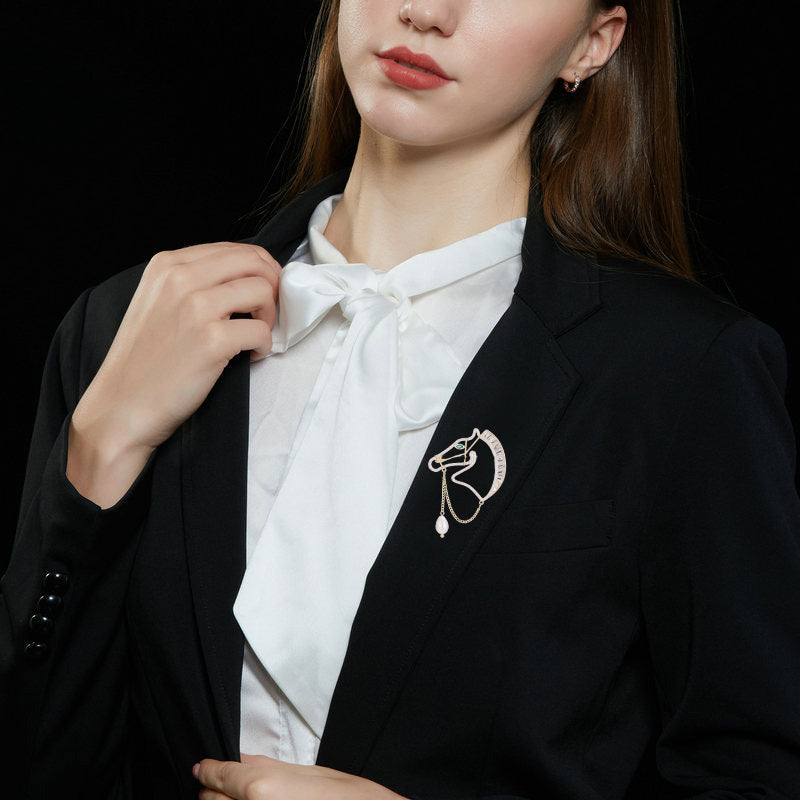 Close-up of the horse brooch styled on a blazer lapel