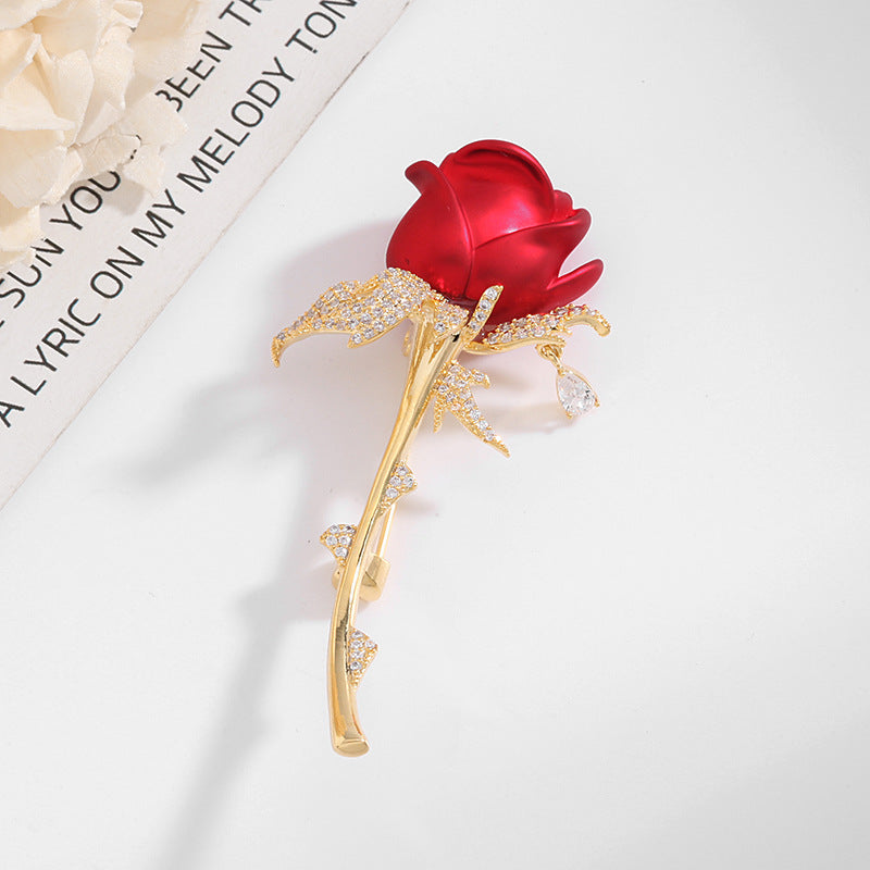 Red rose brooch styled flat lay